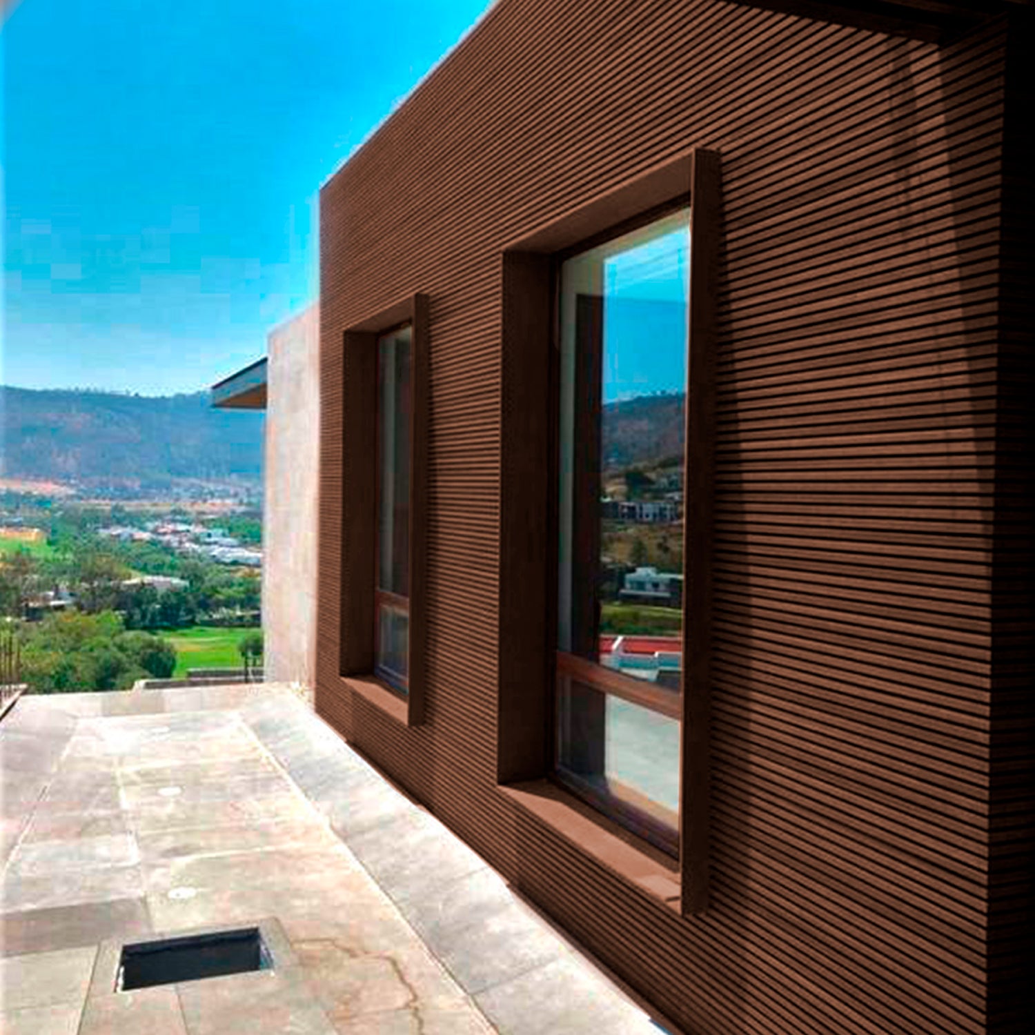 Fachada moderna revestida con cladding Wallpanel WPC chocolate en exterior, solución de revestimiento para muro y envolvente arquitectónica