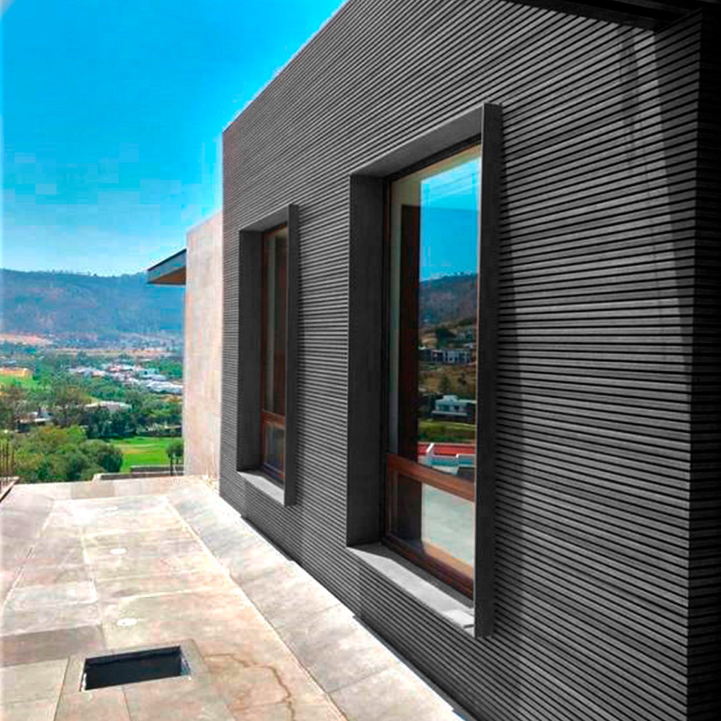 Fachada moderna revestida con cladding Wallpanel WPC gris en exterior, solución de revestimiento para muro y envolvente arquitectónica