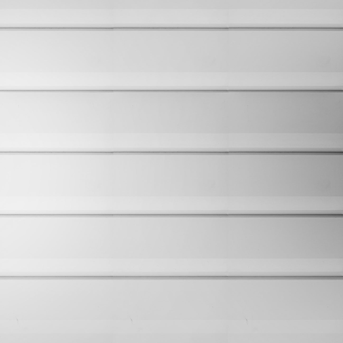 Detalle de montaje de siding metálico blanco instalado con sistema modular para revestimiento exterior de fachadas y muros