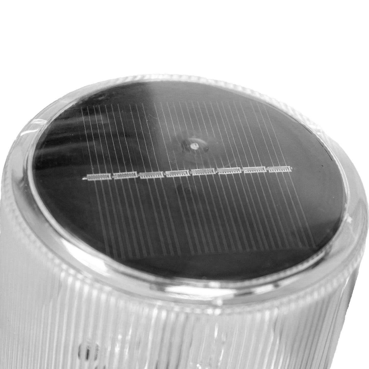 Detalle superior de baliza redonda solar amarilla para conos, con panel solar integrado y lente transparente.