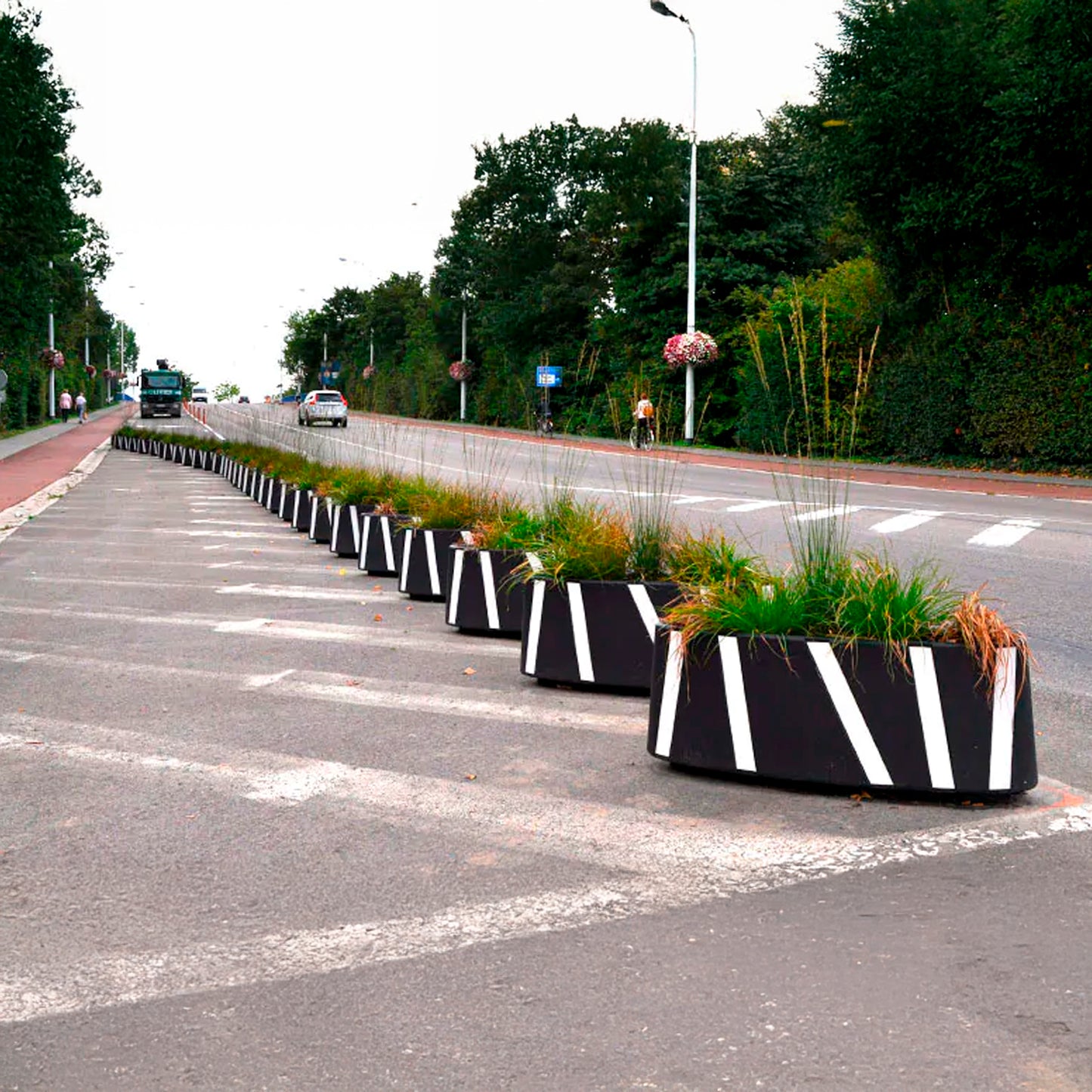Macetas Zicla Zebra 40 alineadas separando ciclovía del tránsito vehicular en vía urbana