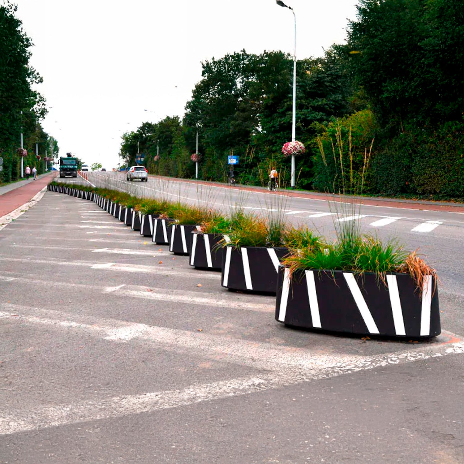 Macetas Zicla Zebra 40 alineadas separando ciclovía del tránsito vehicular en vía urbana