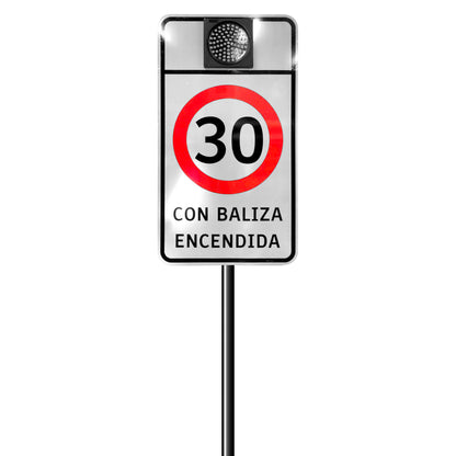 Señal de velocidad máxima 30 km/h con baliza escolar solar encendida sobre poste metálico